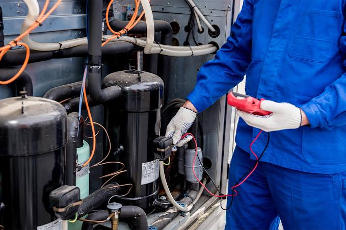Technician testing HVAC compressors and system pressure