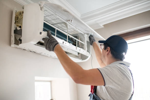 Technician cleaning and servicing an indoor mini-split unit